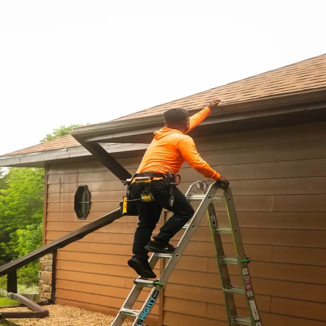 Happy Dad Roofing crew member working at the edge of a roof